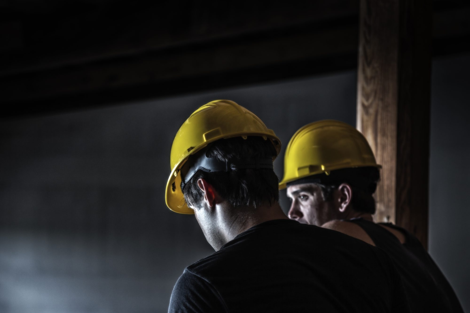 Two night shift construction workers are sitting and talking during the men's midnight work rest break. Copy space.
