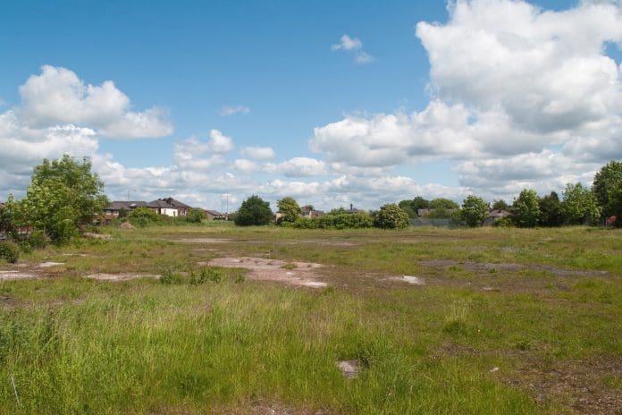 The exposure gap: Can the brownfield boom be sustained without the talent? "An open urban space in Northern England, formerly the site of an an old industrial building, the ground is hard earth and concrete, waiting for redevelopment. Brownfield site."