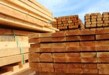 Emerging trends in sustainable construction materials and how to prepare for them Photo showing some huge piles of wooden planks and fence posts, freshly sawn up in a sawmill and piled in the timber yard, ready to be sold to the general public.