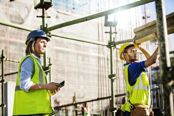 Architect looking at worker working at site construction workers
