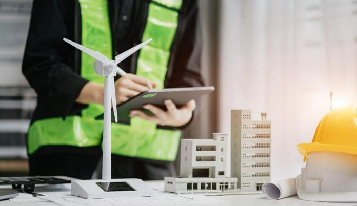 Architect working with blueprints for sketching a construction project, green energy and solar panel concept. green skills