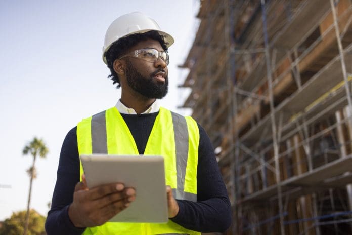 Young Black Male Project Manage with Safety Vest and Helmet André Gunter, head of Pre-sales and Consulting, Idox plc, explores the way construction technologies can maintain a high standard of quality control