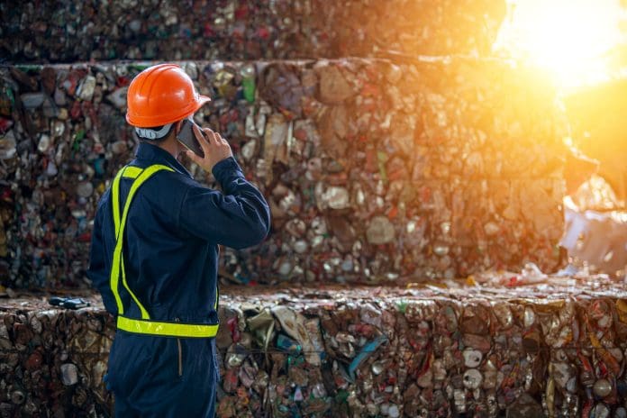 A man calling manager bottles pressed and packed for recycling Worker by recyclable and non-recyclable waste, representing the growth of UK plastic waste