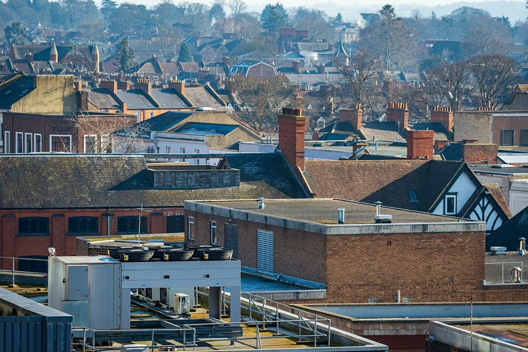 Aerial view over buildings and houses roofs in england uk Clive Feeney, LHC Group managing director, assesses the obstacles to SMEs winning work in the public sector and how to overcome them