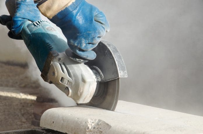 Grinder in motion and dust. Scientists have urged the UK government to reconsider a ban on artificial stone worktops after a rise in cases of silicosis in workers