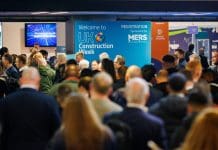 UKCW makes welcome return to Birmingham A crowd of people listen to a talk at UK Construction Week 2024 with the UKCW logo in the background.