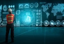 The future of AI systems for construction An man in hi-vis and hard hat looking at digital screens representing AI systems for construction