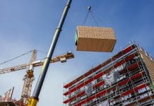 NESC report: Insights and industry responses on the future of MMC in Ireland Construction site of a building with a crane lifting a modular section into place representing MMC in Ireland