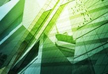CIOB joins #GreenSkills At COP campaign ahead of COP29 to push for sustainability in construction An abstract image of modern glass buildings in green light representing #GreenSkillsAtCOP