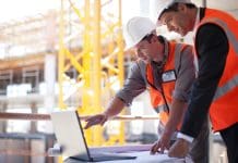 Can AI progress management supercharge lean construction? Two construction workers consult a laptop on site. Can AI progress management supercharge lean construction?
