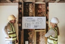 ICW Group is partnering with UK builders to meet housing demand Contractor coworkers looking at floor plan at a construction site, representing UK housing demand