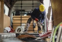 How EPLI can shield your construction business amid 2025 employment law reforms Electrician wearing protective gloves and helmet is preparing cables and equipment inside his van, getting ready for an installation job, representing the need for EPLI