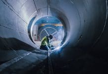 Taming the subsurface data ‘Wild West’ to support productivity Professional Heavy Industry Welder Working Inside Pipe, Wears Helmet and Starts Welding. Construction of the Oil, Natural Gas and Fuels Transport Pipeline. Industrial Manufacturing Factory, representing subsurface mapping