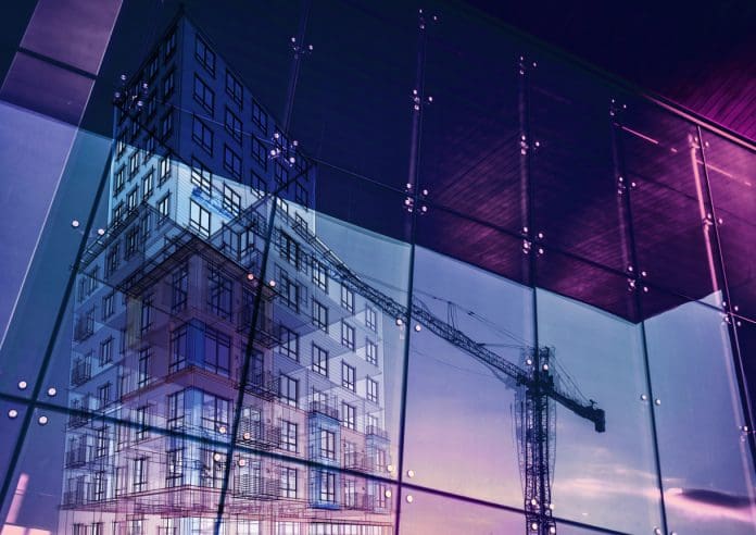 Construction crane and a new high rise building reflected into a newly built office building Building for the future: Key strategies for construction in 2025