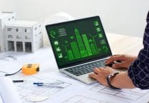 BIM-LCA integration: The future of sustainable construction An architect uses a laptop displaying a sustainable city with blueprints and green building models. Eco-friendly building. Modern city. Green Business. Sustainable energy. Sustainable design.