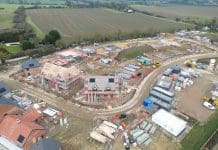 New Towns proposals will require construction recruitment campaign and a focus on offsite construction Drone view of new homes being developed in rural Essex, UK. In the distance is arable farmland. Roof beams can be seen on the detached house in the middle of the image, representing the New Towns Proposals
