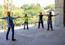 CITB launches Consensus process for 2026-29 Levy Proposals A Multi-Ethnic Group of Construction Workers are Doing Some Morning Exercises at the Construction Site, representing CITB's Consensus