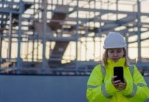 Construction industry welcomes new planning and infrastructure reforms Architect holding smartphone on a construction site - Young female engineer visiting site - Construction female worker on site using mobile, representing industry responses to the new planning and infrastructure bill