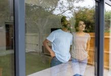 HBF reports high construction industry customer satisfaction Happy Indian couple in a house looking through the window and smiling - moving house concepts, representing construction industry customer satisfaction