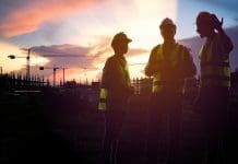 The added value of a structural warranty Teamwork, worker in uniform and wearing safety helmet while working on commercial dock site with container box from cargo freight ship for import export, representing structural warranty