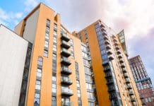 Over 17,000 Build-to-Rent homes completed in last year but future supply looks uncertain Modern high rise blocks of flats in a city centre under partly cloudy sky in summer. A building under construction is visible in distance. Manchester, England, UK, representing BTR