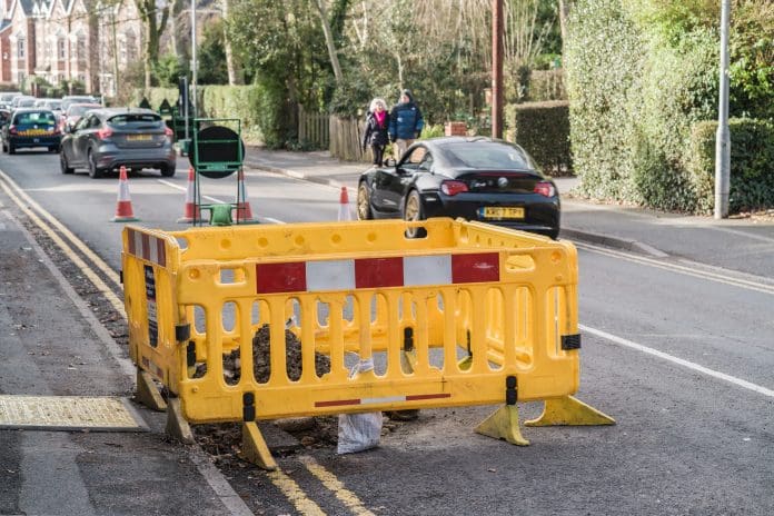 Nantwich, Cheshire, England, February 2nd 2025. Yellow construction barriers, with a car passing roadwork in the background, representing works carried out by NEPO210