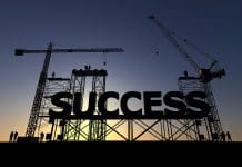 Building success: The power of strategic planning in UK B2B construction marketing Backlit silhouette of a construction site with cranes and steel structures building the word success