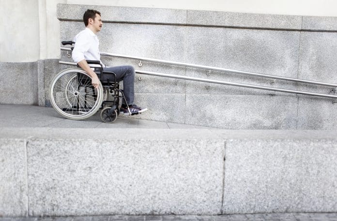 Man in a wheelchair using accessible ramp, representing the need for data validation checks