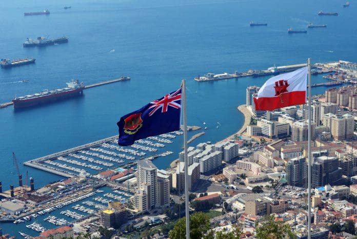 Gibraltar: flag of Gibraltar and the Government Ensign - seen against the Bay of Algerciras with the port, reclamation areas and the town on the lower right - photo by M.Torres, representing the site of IES's latest dynamic simulation project