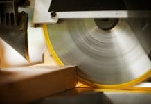 Teen apprentice’s thumb reattached after rotating blade accident Closeup of a circular saw cutting through construction timber. Horizontal shot.