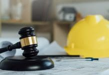 Laing O’Rourke to sue BDP over Bury cladding remediation job Labor and Construction law concept.judge gavel with yellow safety hat,blueprint,home model backgound.Government service protecting safety at job. Worker security protection policy, all representing the Laing O'Rourke - BDP case.