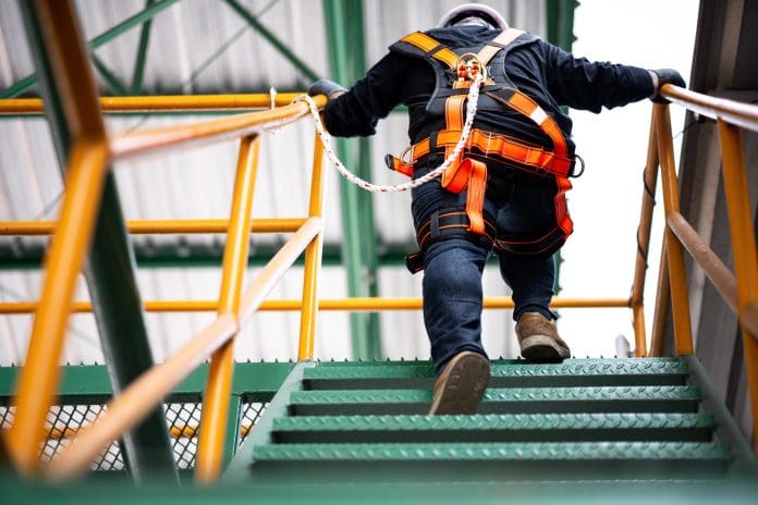 Construction Worker Wearing Safety Harness And Safety Line Working At High Place Construction Worker Wearing Safety Harness And Safety Line Working At High Place