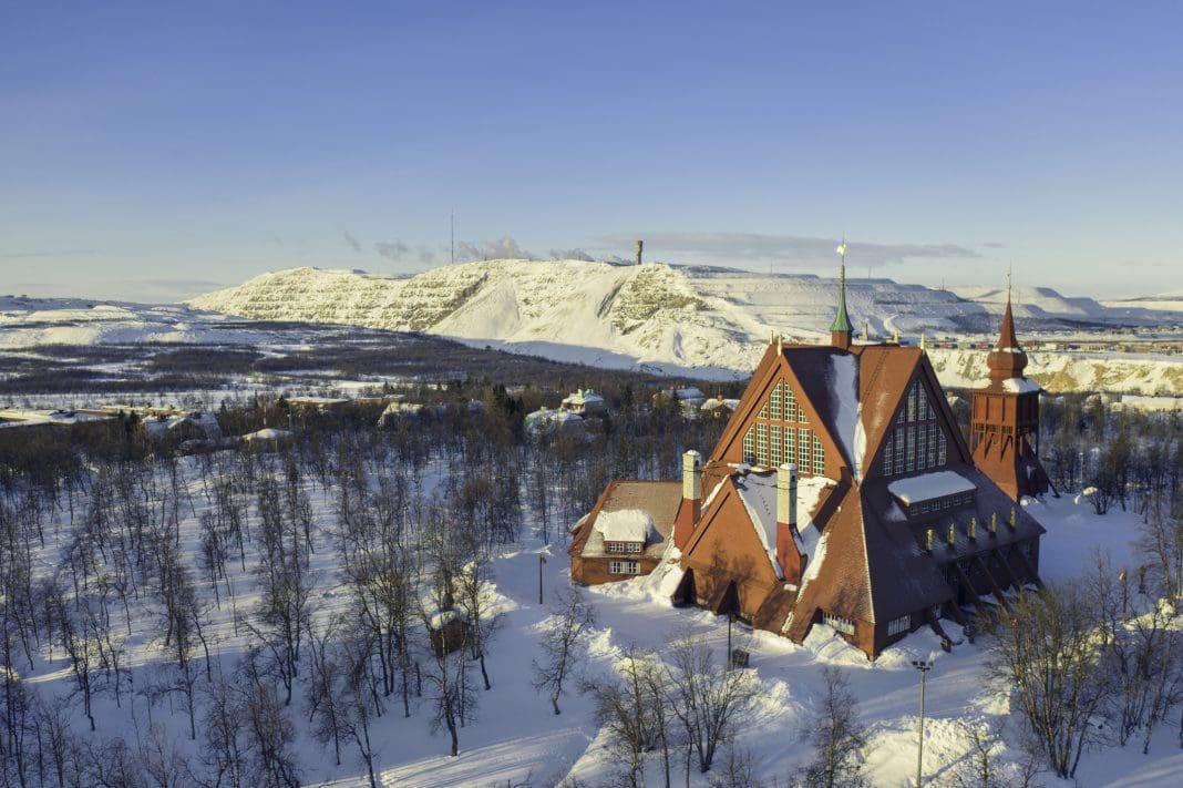 Kiruna Church from 1912, a landmark building built in wood in the town of Kiruna in the northern province of Lapland, Sweden. In the background is the iron mining operations in the town.