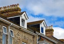 Can we certify a healthy building? Marazion, Cornwall, England, UK: clay chimney pots and dormer windows on rooftops - Victorian row of terrace housing.