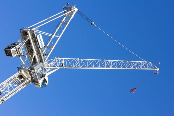 London, England - December 28, 2014: A tower crane seen on the London skyline, with a Balfour Beatty sign on it. Balfour Beatty is a prominent UK construction company.