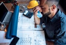 The new KPI in scheduling: Building schedule certainty before day one Overworked,Stressed,Man,Engineer,Having,Headache,While,Working,On,His, representing the importance of schedule certainty in construction