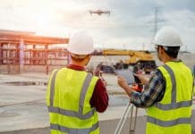 Construction drone market ‘to surpass $21.7bn by 2033’ Drone operated by construction worker on building site,flying with drone.