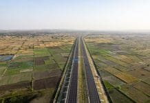 AI ‘set to transform India’s roads’ in drive for growth orbit aerial drone shot of new delhi mumbai jaipur express elevated highway showing six lane road with green feilds with rectangular farms on the sides