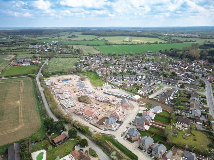 Aerial view of a large new housing development on the outskirts of a rural village in Essex, UK. Aerial view of a large new housing development on the outskirts of a rural village in Essex, UK. The development was on once a Greenfield site, representing the New Towns programme
