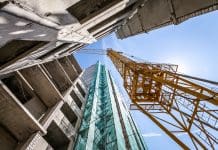 Are you ready for DfMA? Discover what’s next in AEC Yellow Crane on the construction of the building, representing Design for Manufacturing & Assembly (DfMA)