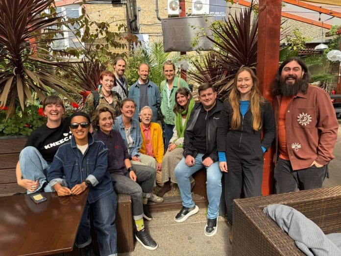 A group of taking part in Retrofit Connect sitting and standing looking towards the camera