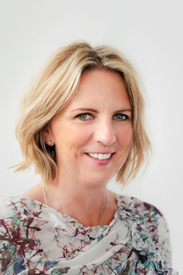 A headshot of Zoe Metcalfe angled towards the camera against a white backdrop