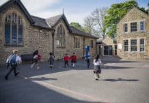 Education secretary sets 2028 deadline for RAAC removal Rear view of children running in their school yard in the North East of England. They are all running towards the door with their backpacks on, representing reaching the 2028 RAAC removal deadline