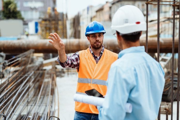 Contractor or engineer on the construction site, wearing PPE, representing digital procurement