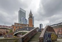 Manchester City Council releases further land to deliver over 700 more homes View across the canal at Castlefield in the centre of Manchester, UK. Reflections of a foot bridge and graffiti can be seen. There are no people in the photograph
