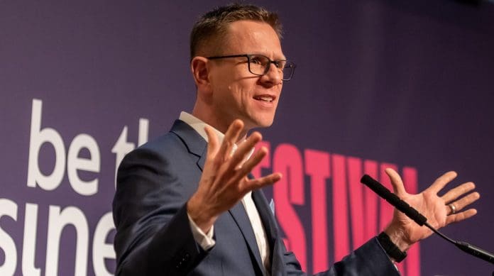 A shot of Anthony Impey speaking on stage