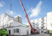 Raising the bar on fire safety in modular builds A crane lifting modular building units into place at the Desborough Road development by Premier Modular, representing fire safety in modular buildings