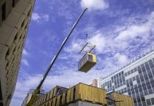 Ireland’s offsite manufacturing sector: “We have capacity. What our members need now is a robust and reliable pipeline.” Modular wood commercial building prefabricated assembled with crane, representing Ireland's offsite manufacturing