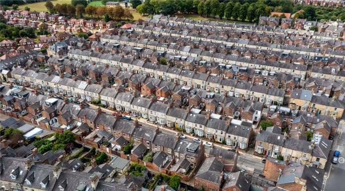 Aerial view of old terraced houses on back to back streets in the suburbs of a large UK city, representing equitable retrofit