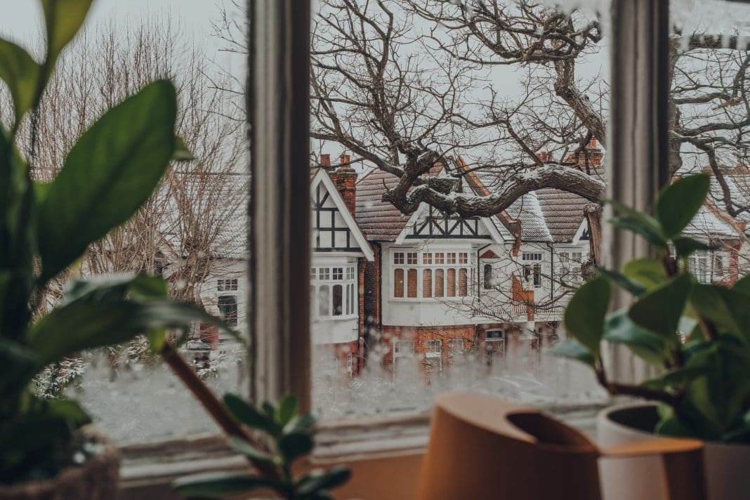 View Of The Snow Through The Window From Inside The House. Selective Focus. Photo taken in London, United Kingdom, representing the need for a warm homes plan